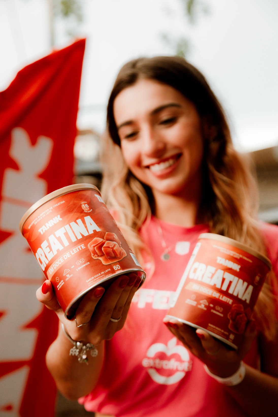Creator segurando duas latas de creatina TANNK